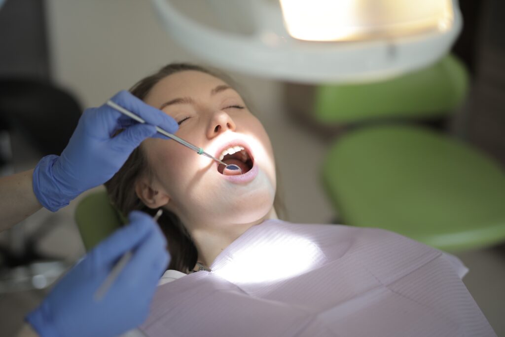 Dentist performing a comprehensive oral health evaluation during a patient examination.